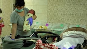Une infirmière s'occupant d'un bébé né de GPA dans un abri sous-terrain à Kiev, en Ukraine
