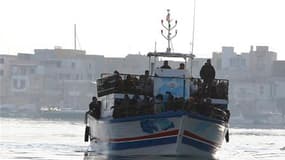 Un bateau d'immigrants arrive à Lampedusa, en Italie, dimanche. La Tunisie a déployé des soldats pour endiguer le flux de migrants clandestins qui tentent de gagner l'Italie, où seraient arrivés plus de 4.000 Tunisiens ces derniers jours. /Photo prise le