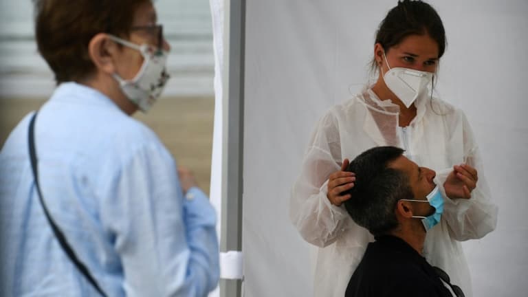 Une infirmière fait un prélèvement sur un patient dans un centre mobile de dépistage du coronavirus, sur la plage de Pentrez à Saint-Nic, dans l'ouest de la France le 12 août 2020