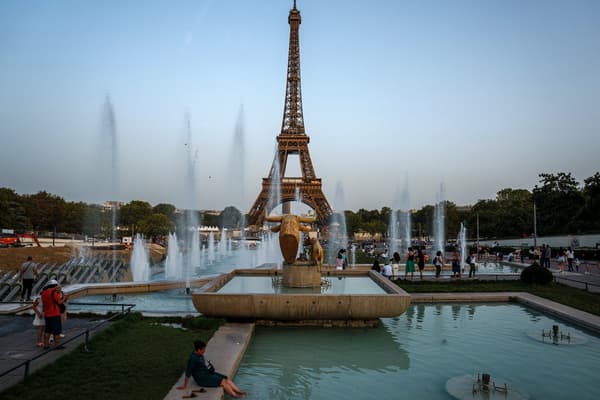 Des habitants se rafraichissent  dans l'eau du bassin du Trocadéro à côté de la Tour Eiffel, durant une vague de chaleur tardive, à Paris le 5 septembre 2023.