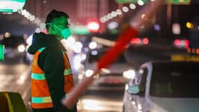 Un membre des forces de sécurité près d'une autoroute de Wuhan, en Chine. 