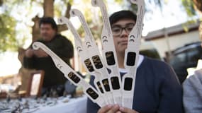 Un jeune homme présente des lunettes pour pouvoir observer l'éclipse solaire du 2 juillet, le 30 juin 2019 à Vicuña, au Chili. 