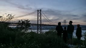 Une famille observe le Pont du 25-Avril, les lumières éteintes, lors d'une importante coupure de courant qui a touché toute la péninsule ibérique, le 28 avril 2025 à Lisbonne (photo d'illustration).