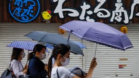 Des personnes se protègent de la pluie alors que la tempête tropicale Nepartak s'approche du Japon (photo d'illustration)