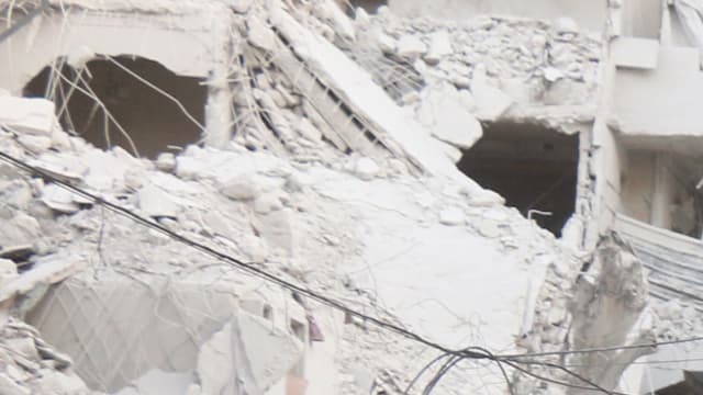 Une famille dans une rue dévastée d'Alep, le 23 septembre 2016.