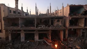 Un feu de camp près d'un immeuble largement détruit à Khan Younès, dans le district de Kheeza, en territoires palestiniens, le 30 novembre 2023