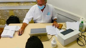 Un médecin reçoit un patient avant de le vacciner contre le Covid-19, le 31 août 2021 aux Restos du Coeur de Bordeaux