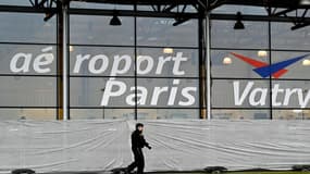 Un gendarme patrouille devant l'aéroport de Vatry, dans la Marne, le 23 décembre 2023, devant des bâches blanches installées sur les vitres du hall de l'aéroport où sont confinés plus de 300 Indiens