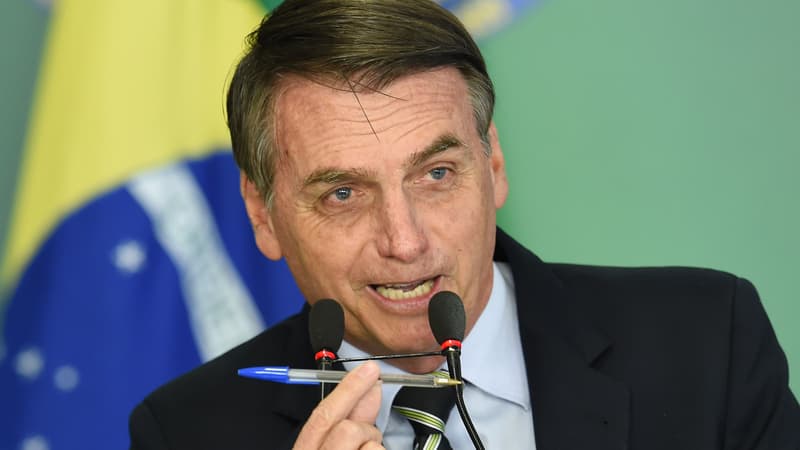 Jair Bolsonaro montre le stylo avec lequel il a signé le décret.