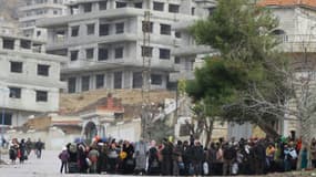 Des habitants de la localité assiégée de Madaya attendent un convoi d'aide de la Croix-Rouge syrienne, le 14 janvier 2016