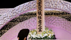 Le Premier ministre japonais Shinzo Abe devant l'autel en hommage aux victimes du tremblement de terre et du tsunami qui a ravagé le nord-est du pays le 11 mars 2011. Shinzo Abe a promis lundi d'accélérer la reconstruction dans la région de Fukushima, thé