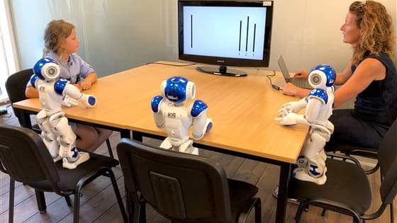 L'enfant entouré des robots pendant l'expérience