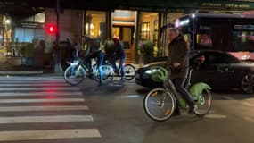 Des cyclistes parisiens arrêtés à un feu tricolore - Image d'illustration