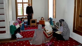 Un adjoint de l'imam dans la mosquée Sinan Pacha, au Kosovo, enseignant la prière à des femmes