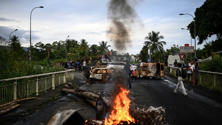 Des véhicules brûlés bloquent une route à Sainte-Rose, le 30 novembre 2021 en Guadeloupe