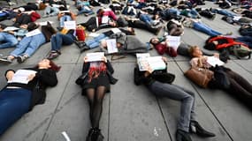 Des manifestantes tiennent des pancartes portant les noms des femmes victimes de féminicides en 2019 durant un die-in place de la République, le 19 octobre 2019