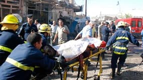 Evacuation d'une victime à Kut, à 150 km au sud-est de Bagdad. L'Irak a été lundi le théâtre d'une série de quatre attentats dont le plus grave perpétré dans la ville de Kut a fait au moins 37 morts et 68 blessés. /Photo prise le 15 août 2011/REUTERS/Jaaf