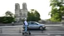 Un homme passe en trottinette électrique devant la cathédrale Notre-Dame de Paris le 23 août 2023