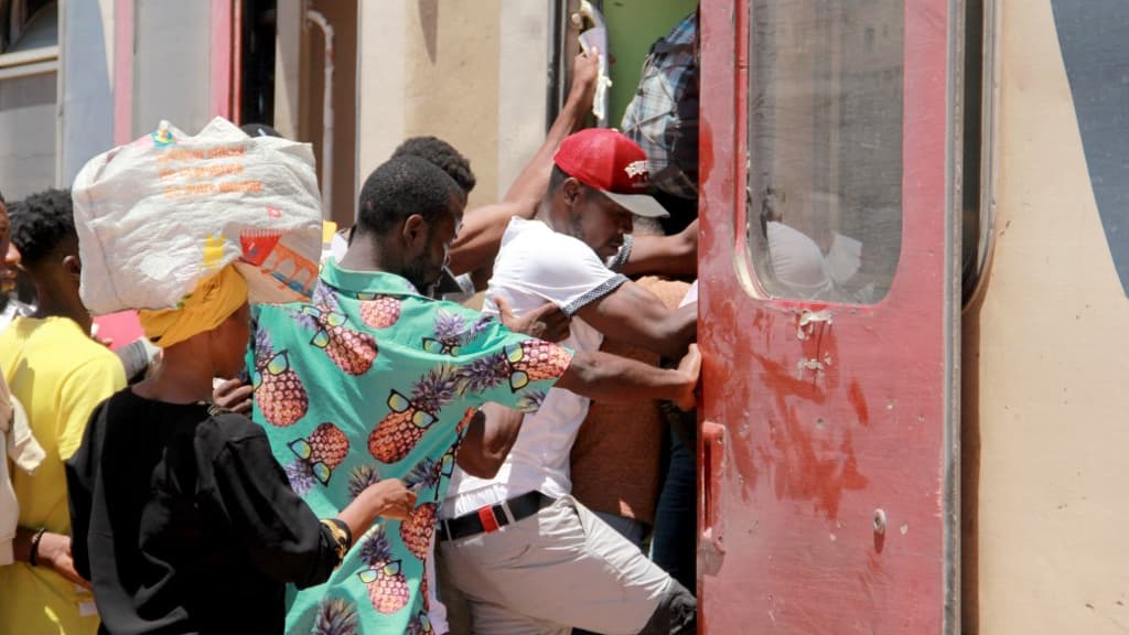 Des migrants montent à bord d'un train le 5 juillet 2023, alors qu'ils fuient vers Tunis dans un contexte de troubles à Sfax.