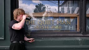 Un homme boit une bière lors des célébrations de la Saint-Patrick, le dernier jour d'ouverture du célèbre pub irlandais The Quiet Man, à Flemington, dans la banlieue de Melbourne, le 17 mars 2025.