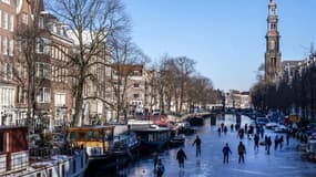 Un canal gelé d'Amsterdam et ses patineurs 