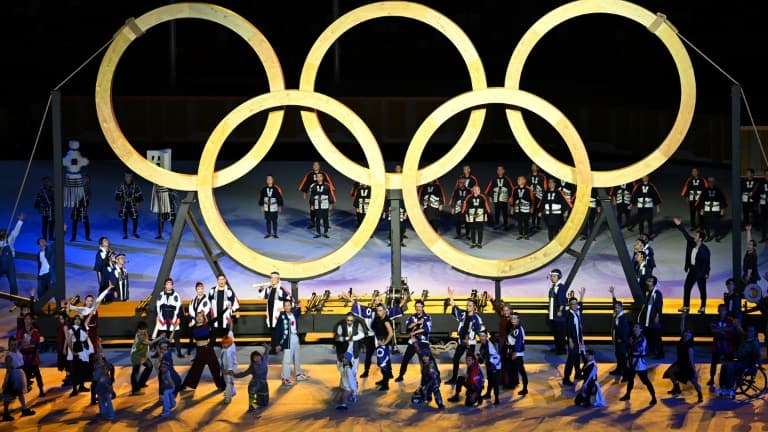 Des anneaux olympiques en bois sont hissés par des participants lors de la cérémonie d'ouverture des Jeux, le 23 juillet 2021 au Stade Olympique à Tokyo