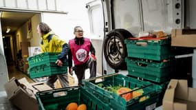 Des bénévoles des Restos du coeur déchargent une camionnette lors du lancement de la 39e campagne de l'association le 21 novembre 2023 à Grenoble