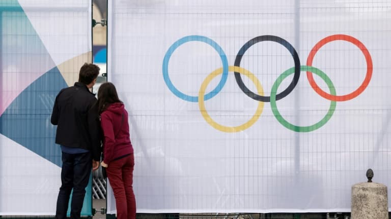 Un couple regarde entre les barrières entourant un site olympique à Paris, le 16 juillet 2024. (Illustration)