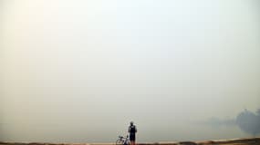 Un cycliste prend en photo l'épaisse fumée toxique qui vient des feux de brousse, au nord de Sydney, le 10 décembre 2019