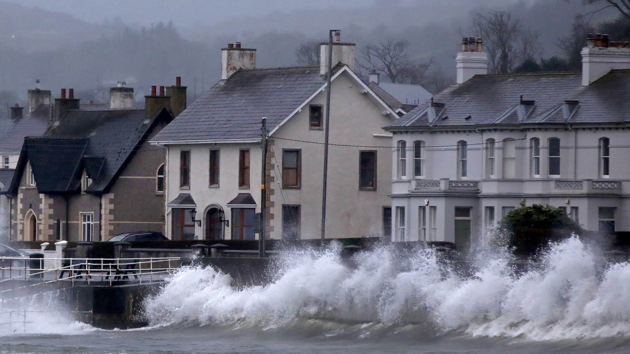Les vagues se brisent contre la digue à Carnlough, sur la côte nord-est de l'Irlande du Nord, le 24 janvier 2025, lors du passage de la tempête Eowyn.