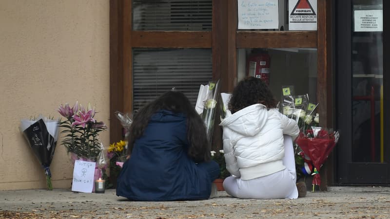 Des collègues et élèves se recueillent devant le collège de Conflans-Sainte-Honorine, au lendemain de l'attentat qui a coûté la vie au professeur Samuel Paty