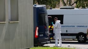 Un enquêteur médico-légal près de véhicules de gendarmerie garés à proximité d'un complexe d'habitation où un individu a tué son partenaire et leurs deux enfants avant d'être arrêté, dans la ville de Mormant, à environ 60 km au sud-est de Paris, le 7 septembre 2024.
