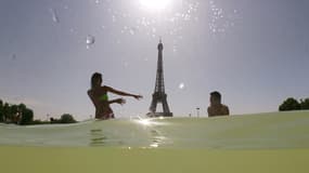 Des Parisiens se rafraîchissent dans les bassins du Trocadéro, le 25 juillet 2019 à Paris. 