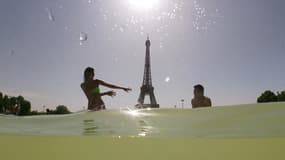 Des Parisiens se rafraîchissent dans les bassins du Trocadéro, le 25 juillet 2019 à Paris. 