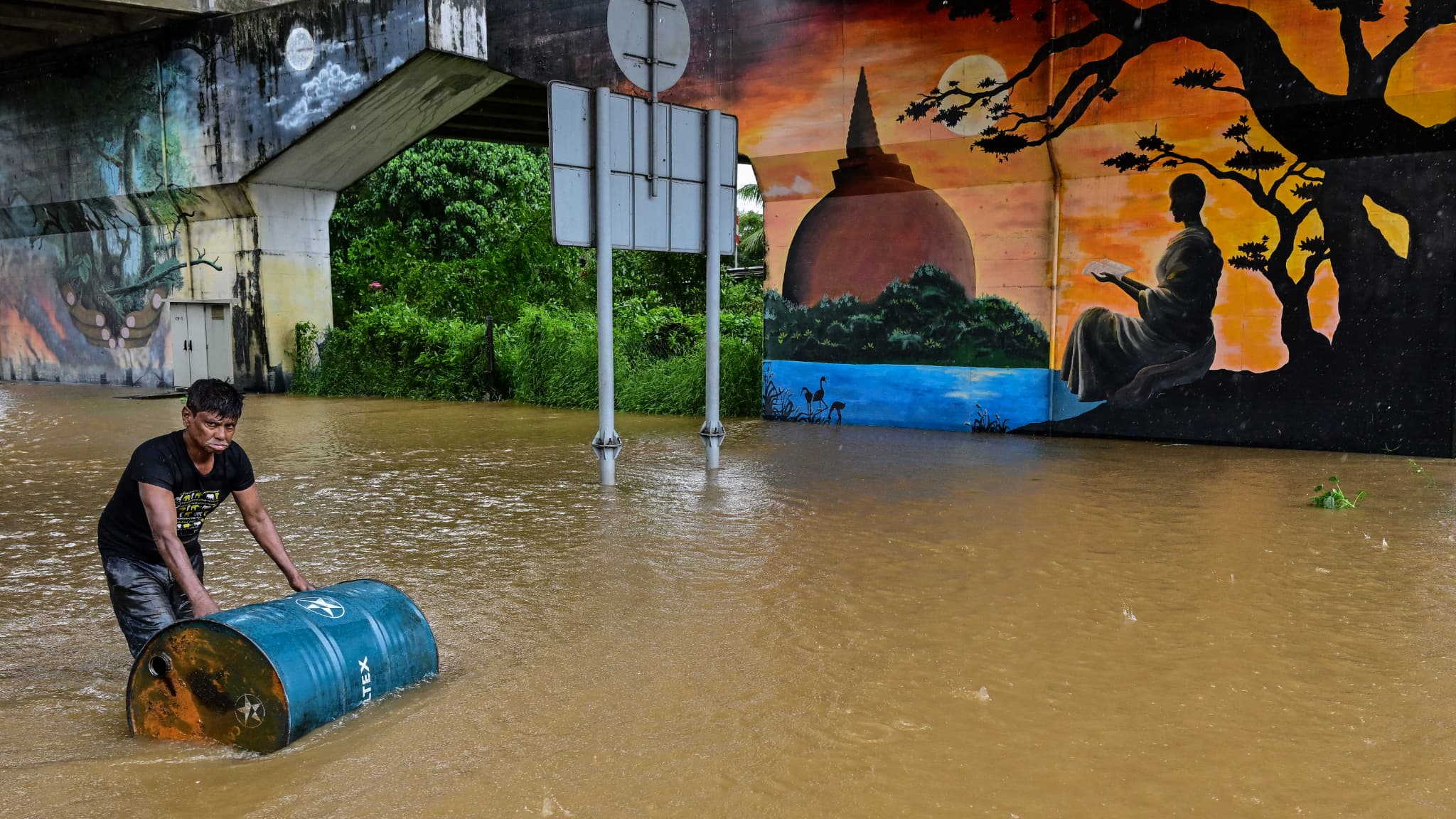 Un homme et ses affaires traversent à gué une route inondée après de fortes pluies à Kaduwela, dans la banlieue de Colombo, le 28 novembre 2025.