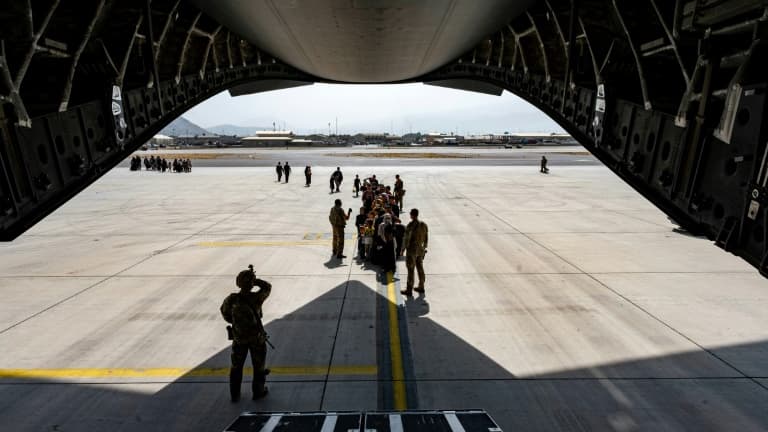 Des Afghans font la queue avant de monter à bord d'un avion de l'US Air Force pour évacuer Kaboul, le 20 août 2021