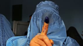 Une femme qui vient de voter montre son doigt plein d'encre à Herat, le 5 avril 2014.