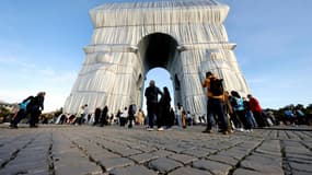 Des personnes devant l'Arc de Triomphe "empaqueté", oeuvre posthume de Christo et de son épouse Jeanne-Claude, le 30 septembre 2021 à Paris