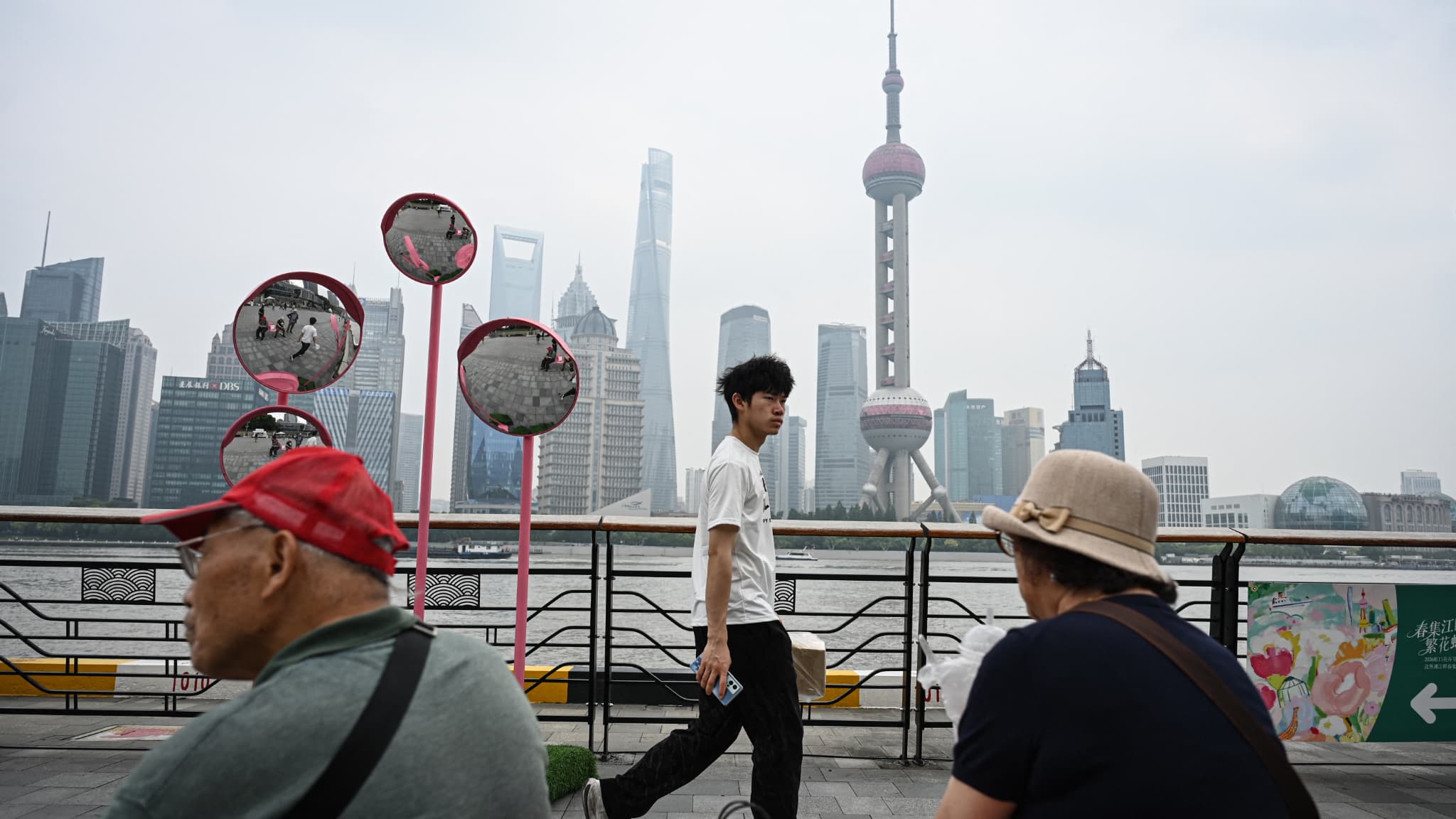 Un homme marche tandis que deux personnes âgées se reposent sur la promenade du Bund Nord, le long du fleuve Huangpu à Shanghai, le 21 mai 2026. Un homme marche tandis que deux personnes âgées se reposent sur la promenade du Bund Nord, le long du fleuve Huangpu à Shanghai, le 21 mai 2026.