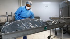 Un employé de la morgue travaille avec le corps d'une victime du COVID-19 dans une morgue d'un hôpital de Porto Alegre, dans l'État du Rio Grande do Sul, au Brésil, le 4 mars 2021.