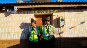 Des policiers à Copiapo devant la demeure de Victor Segovia, l'un des 33 mineurs qui sont restés prisonniers sous terre pendant deux mois. Les "emmurés de l'Atacama" ont été accueilli en héros dans leurs foyers, alors que les détails de leurs 69 jours de