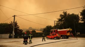 Les pompiers prennent position à Cazaux le 14 juillet 2022 alors que la ville est en cours d'évacuation après la propagation du feu de forêt de La Teste-de-Buch à proximité des habitations. 