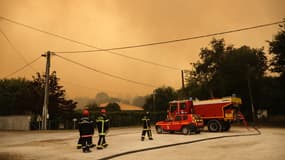 Les pompiers prennent position à Cazaux le 14 juillet 2022 alors que la ville est en cours d'évacuation après la propagation du feu de forêt de La Teste-de-Buch à proximité des habitations. 