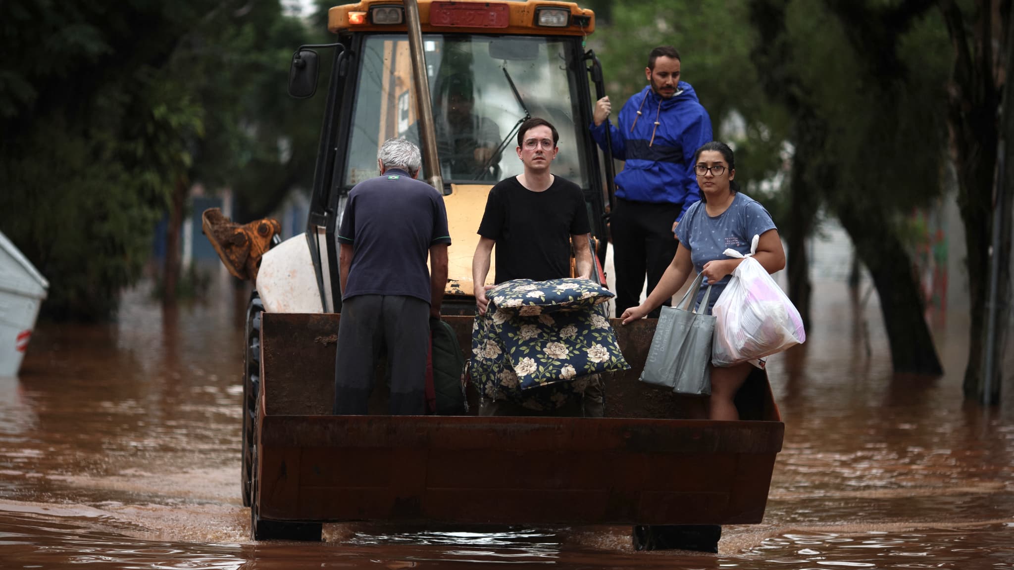 Des personnes sont évacuées d'une zone inondée à l'aide d'une pelleteuse dans le quartier de São Geraldo à Porto Alegre, dans l'État du Rio Grande do Sul, au Brésil, le 4 mai 2024.