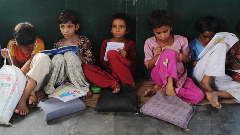 Des élèves lisent dans une salle de classe, dans l'Uttar Pradesh, en Inde, le 30 août 2012.