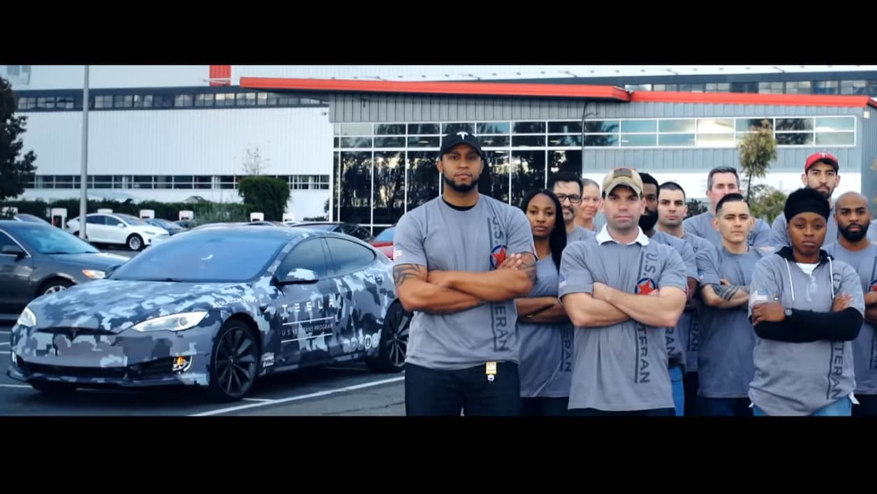 Des employés de Tesla prenant la pose devant l'usine de Fremont. Des employés de Tesla prenant la pose devant l'usine de Fremont.