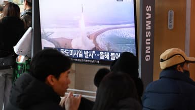 Des personnes sont assises devant un écran de télévision diffusant un journal télévisé avec des images d'archives d'un essai de missile nord-coréen, dans une gare de Séoul, le 4 janvier 2026.