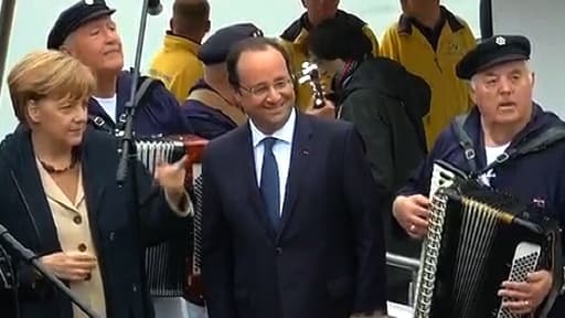 Angela Merkel et François Hollande écoutent un morceau d'accordéon avant de partir voguer sur la mer Baltique, le 9 mai 2014.