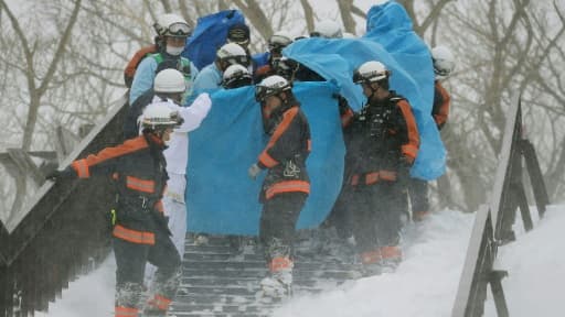 Des pompiers transportent un survivant d'une avalanche, le 27 mars 2017 dans la ville de Nasu, au nord de Tokyo