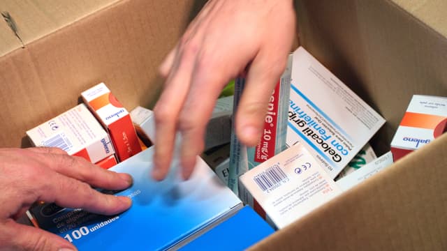 Caisse contenant des boîtes de médicaments. (Illustration)